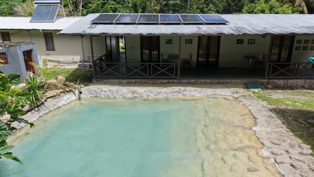 The cabins and shaded veranda beside the spring pool