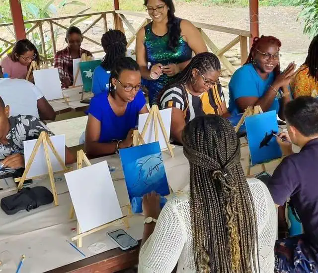Group painting workshop under a shed